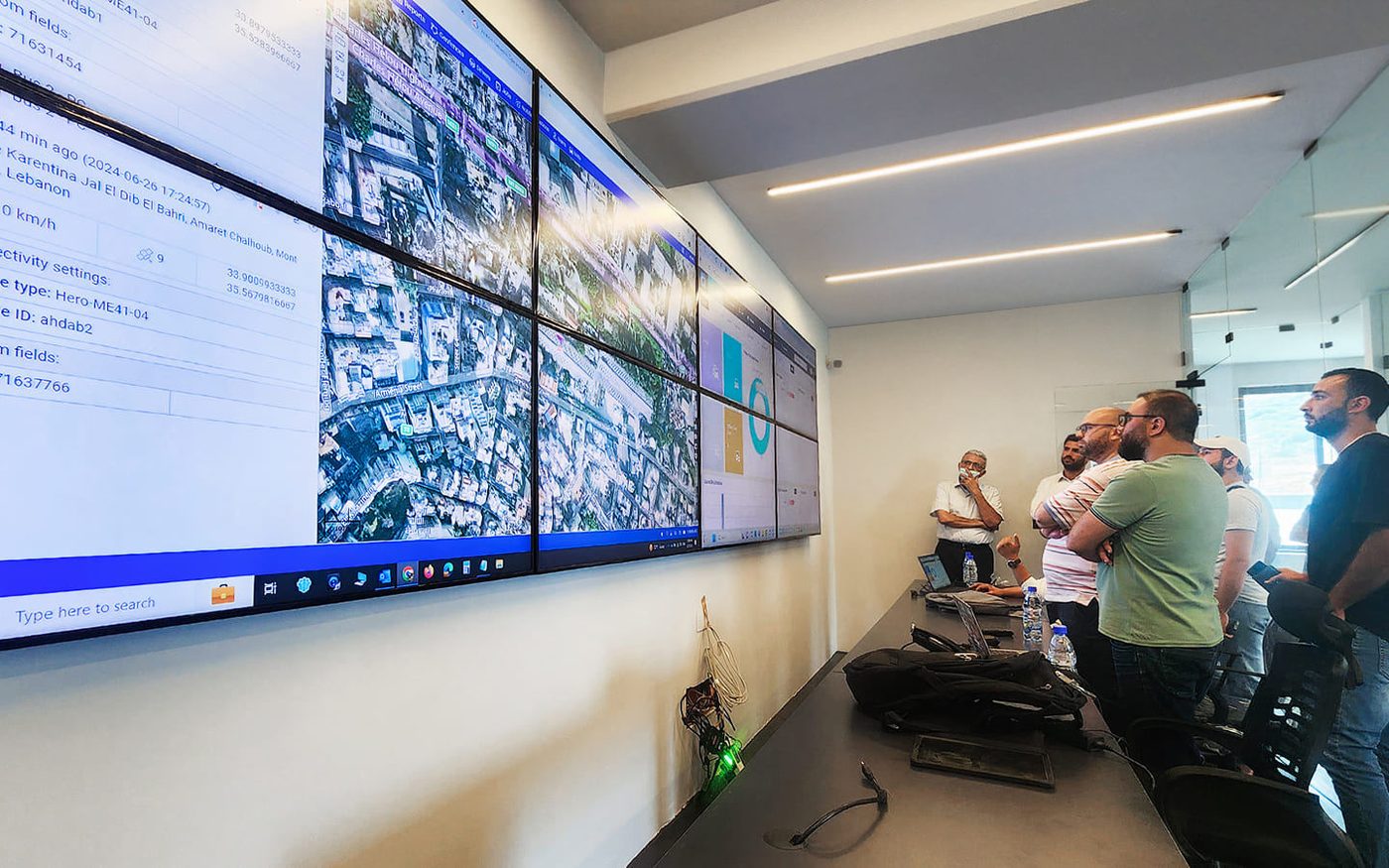 Team davanti a una parete di monitor con dati