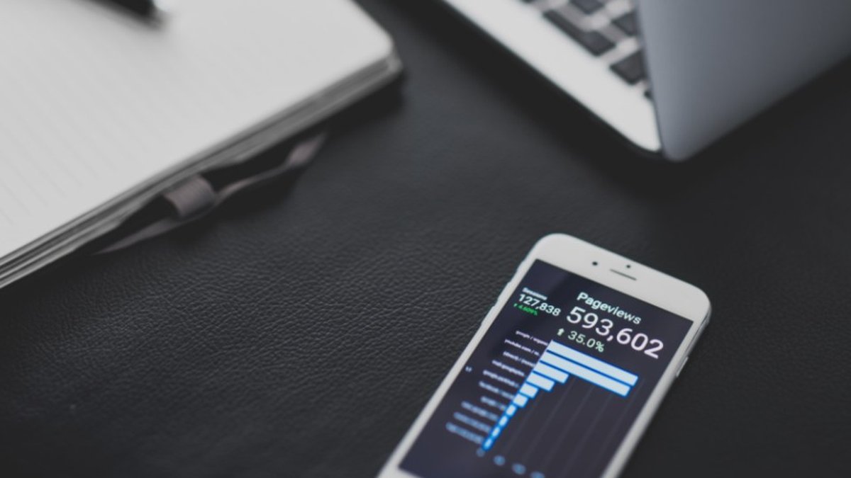 Smartphone con dashboard di dati accanto a un computer portatile